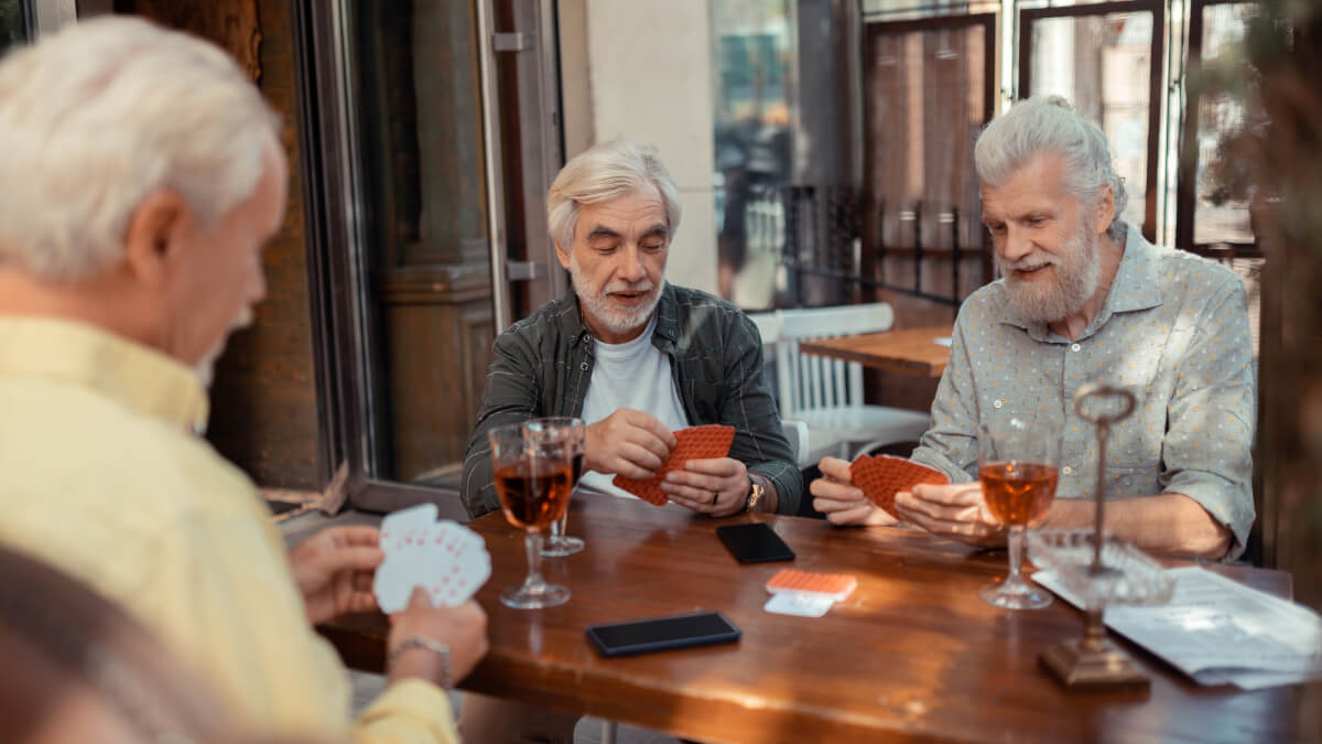 Três homens mais velhos jogando cartas. 